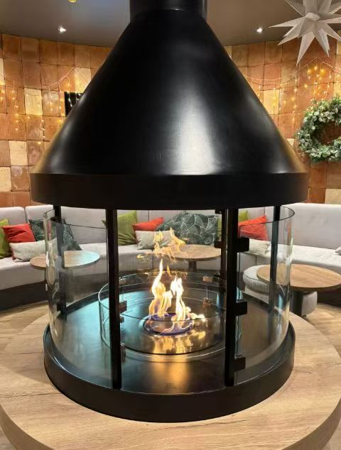 SEFIRE round intelligent ethanol fireplace installed as a circular centerpiece with glass enclosure